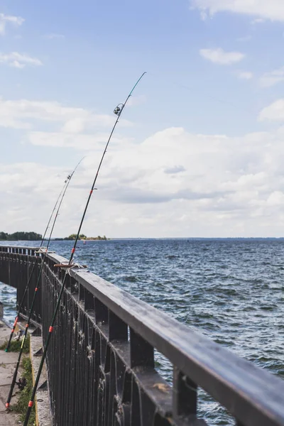 Diverse canne da pesca appoggiate sulla recinzione sul molo — Foto Stock