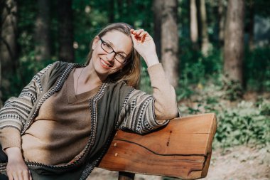 İnce sarışın tahta bankta oturan