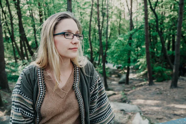 Slanke blonde tegen de achtergrond van de groene bomen — Stockfoto