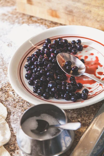 Блюдо с черными круглыми ягодами на столе — стоковое фото