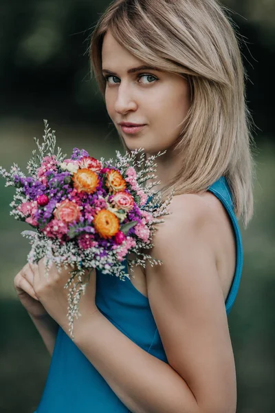 Güzel sarışın portresi ile buket çiçek — Stok fotoğraf