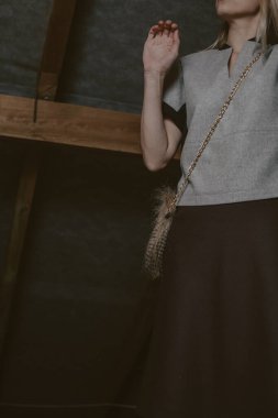 Deri çizmeli kadın bacakları tahta zeminde duruyor.