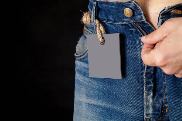 Tag quadrada pesa em jeans azul close-up — Fotografia de Stock
