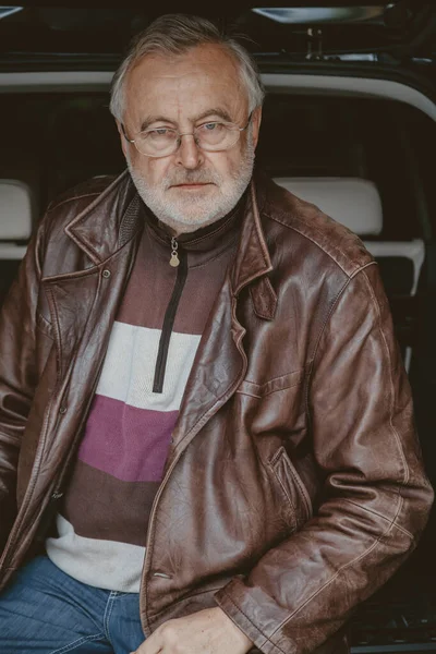 Handsome elderly man in glasses and leather jacket close-up — Stock Photo, Image