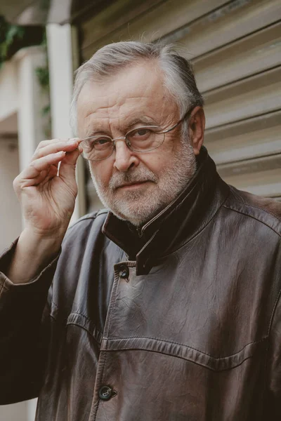 Handsome elderly man in glasses and leather jacket close-up — Stock Photo, Image