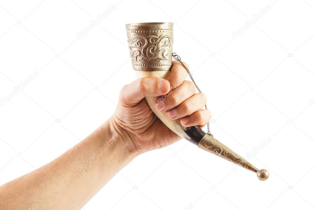 Hand holds horn for wine on white background