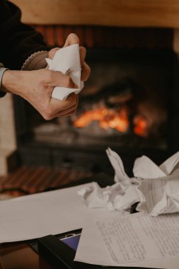Elleri yanan şöminenin önünde çarşafları buruşturur.