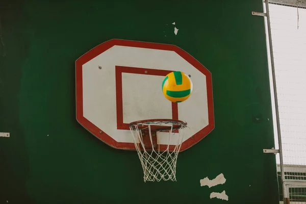 Pruhovaný míč nad basketbalovým košem — Stock fotografie