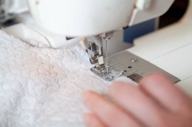 Terzi el rehberi modern dikiş makinesine dikiş atar.