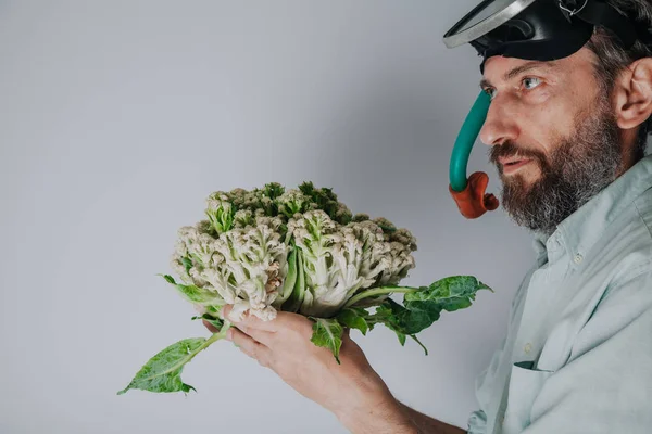 Man in swimming mask is holding  cauliflower