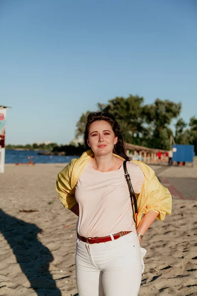 Belle femme taille plus en veste jaune sur la plage de sable — Photo