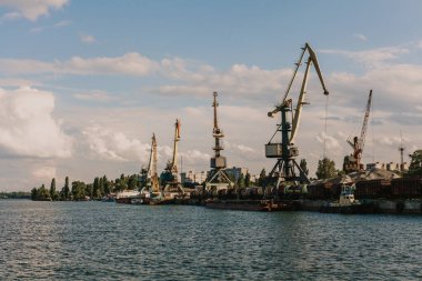 Gökyüzü arka planında nehir limanında portal vinçler