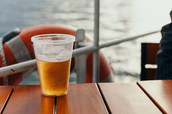 Пластиковое стекло с пивом на борту корабля
