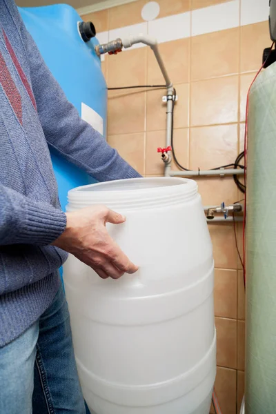 Händerna håller plast behållare i vatten behandlingsrum — Stockfoto