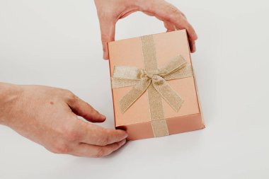 Beyaz arka planda kurdele yayı olan elleri açık kutu