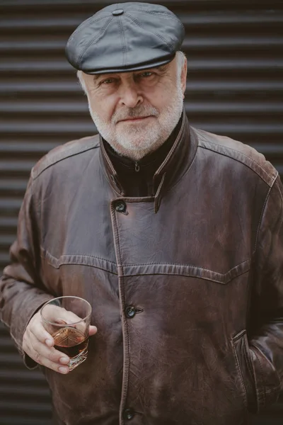 Portrait of gray-haired man with glass of whiskey — Stock Photo, Image