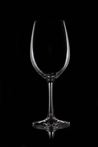 Copo de vinho de vidro fica em vidro no fundo preto — Fotografia de Stock