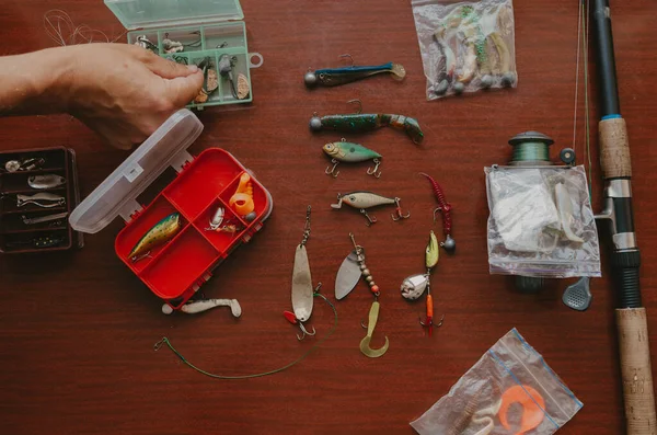 Fisherman hand takes artificial lure out of box — Stock Photo, Image