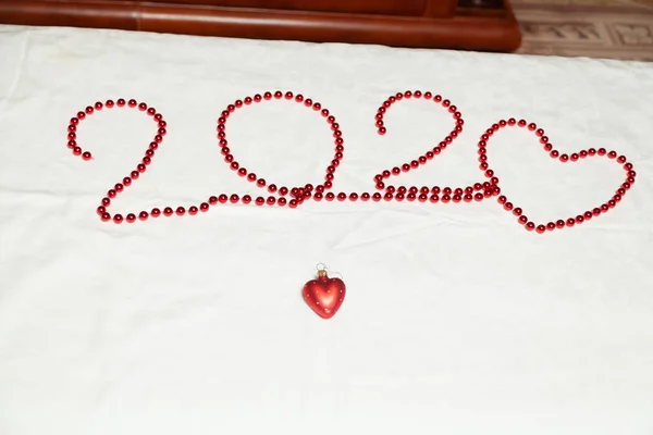 Beyaz arka planda kırmızı boncuklardan oluşan Sevgililer Günü kartı — Stok fotoğraf