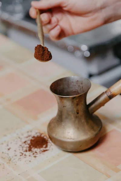 Рука наливает молотый кофе в Cezve крупным планом — стоковое фото
