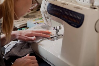 Terzi iş başında. Bir kadın gözlük bir Dikiş dikiş makine yumuşak bir bezle yapar