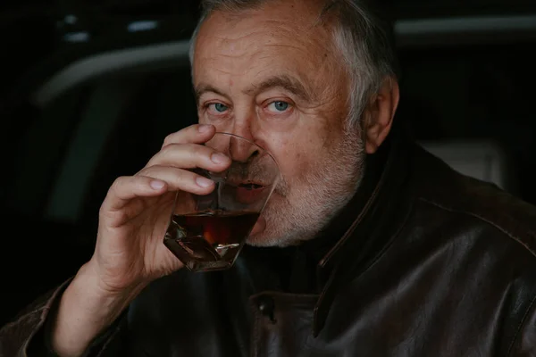 Anciano Con Una Barba Gris Una Chaqueta Cuero Bebe Whisky — Foto de Stock