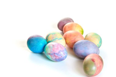 Paskalya tatiline özen göster. Farklı renklerde boyanmış birkaç tavuk yumurtası beyaz bir sırt grubunda.