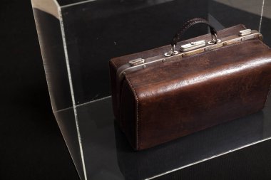 Müzedeki cam bir kutunun içinde duran müzik enstrümanının antika deri akortçusu.