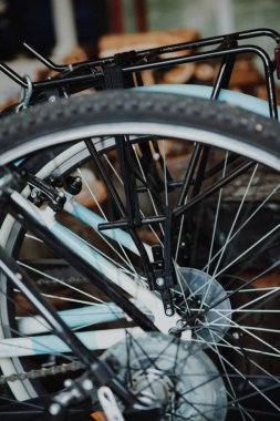 Yakınlarda bir garajda iki bisiklet duruyor. Modern bir bisikletin arka tekeri. Başka bir teknenin arkasında