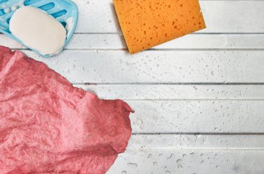 Islak pembe bulaşık bezi, yapışkan sabun çubuğu ve çelikten yapılmış turuncu mutfak süngeri.