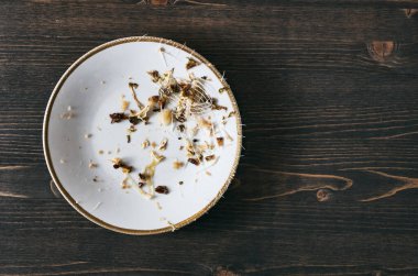 Tek bir tabakta balık kemikleri. Ahşap masa arka planı. Fotokopi alanı olan üstten üste düz fotoğraf