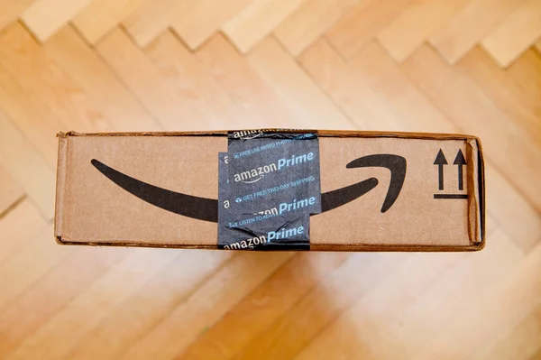 Paris, france - 28. Januar 2016: amazon prime Logotyp auf Pappkartonseite von oben auf einem Parkettboden gedruckt. amazon ist ein amerikanisches E-Commerce-Unternehmen, das weltweit vertrieben wird — Stockbild Amazon prime smile Pfeil auf einem Paketkarton — Stockfoto