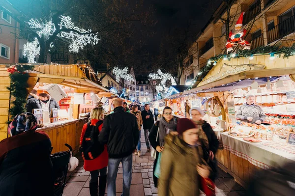 Besucher kaufen glücklich ein und bewundern Weihnachtsmarkt — Stockfoto