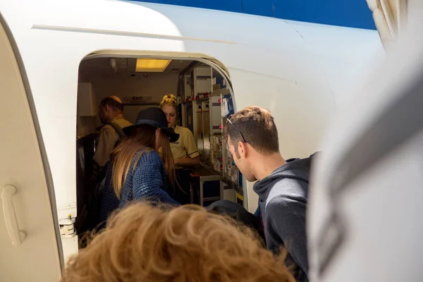 Люди, входящие в самолет через дверной аэропорт — стоковое фото
