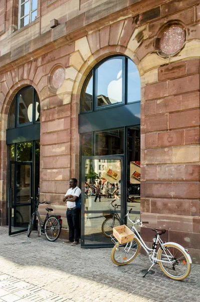 Мужчина ждет возле магазина Apple возле винтажного велосипеда — стоковое фото