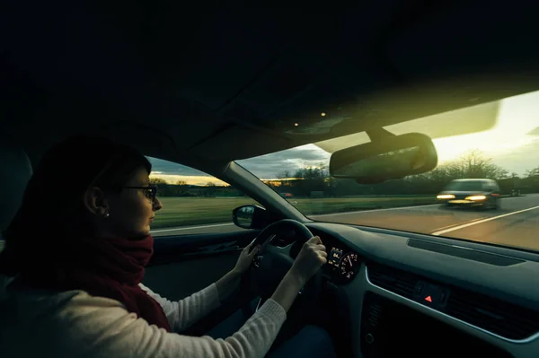 Mulher dirigindo na autobahn alemão ao entardecer — Fotografia de Stock