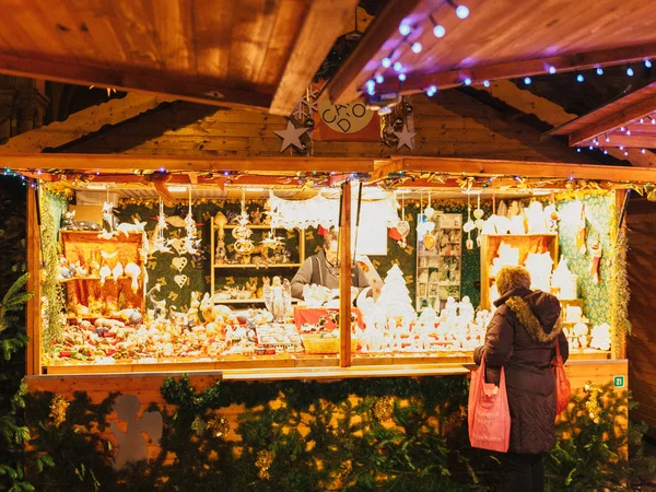 Femme achetant des jouets et des cadeaux de Noël étal chalet marché — Photo