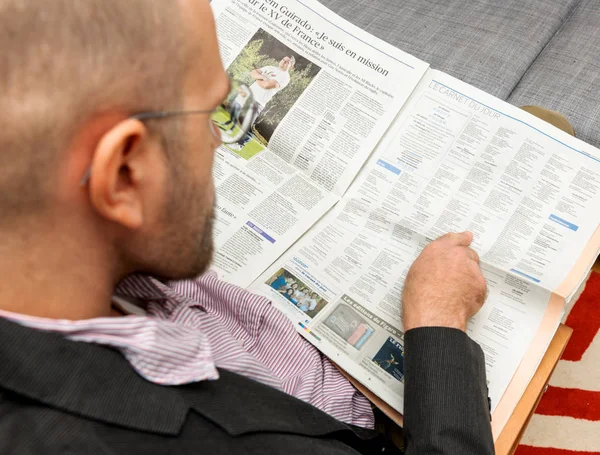 Hombre leyendo obituarios en el periódico — Foto de Stock