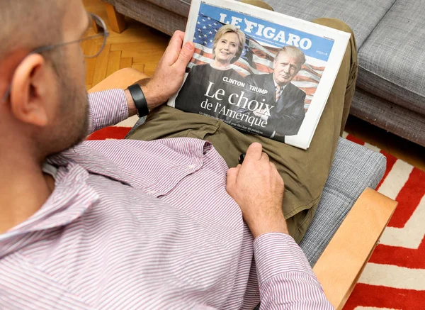 Człowiek, czytanie Le Figaro magazine Hillary Clinton i Donald Trump — Zdjęcie stockowe