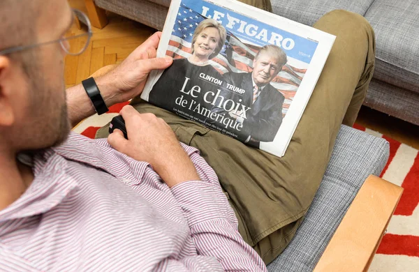 Człowiek, czytanie Le Figaro magazine Hillary Clinton i Donald Trump — Zdjęcie stockowe