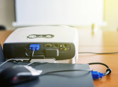 Sunum odası içinde laptop bağlı projektör