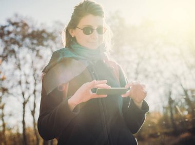Vintage görüntü - fütüristik telefon açık güneş fişek kullanan kadın 