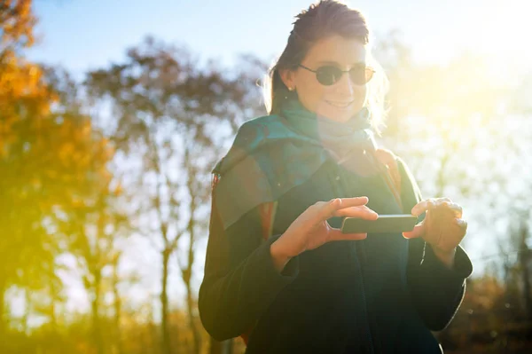 Smart Woman using futuristic phone outdoor sun flare