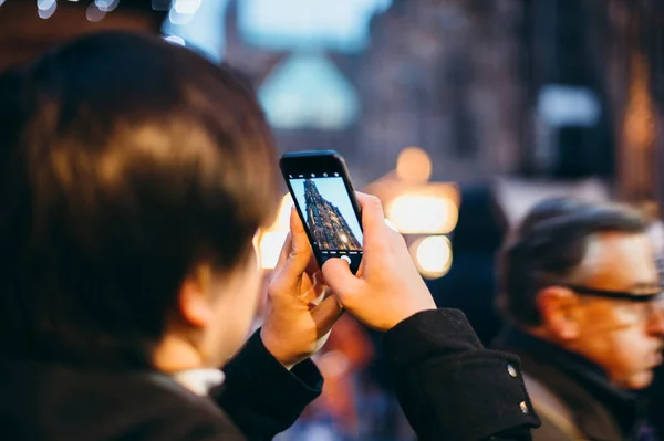 Man op smartphone Notre-Dame kathedraal — Stockfoto