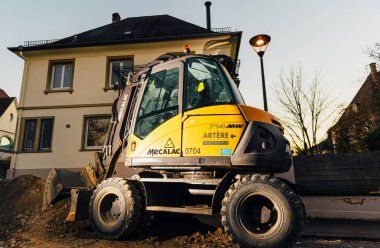 Gece sokakta Mecalac Ekskavatör aydınlatılmış