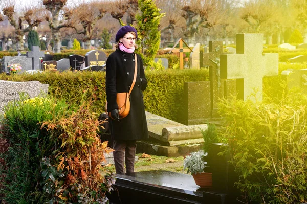 Woman at cemetery and light flare — Stock Photo, Image