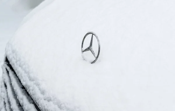 Iconic Mercedes-Benz logotype insignia covered with snow — Stock Photo, Image