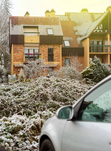 House facade with car and snow