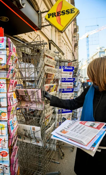 Mujer compra periódico de prensa de EE.UU., Reino Unido y Alemania a un noticiero — Foto de Stock