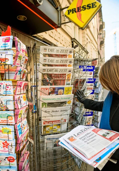 Mujer compra periódico de prensa de Estados Unidos en un quiosco — Foto de Stock